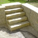 Gabions de soutènement entourant un escalier dans un espace extérieur de type jardin.