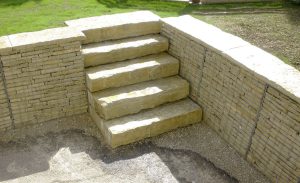 Gabions de soutènement entourant un escalier dans un espace extérieur de type jardin.