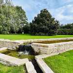couverture de mur en pierre naturelle devant une fontaine dans un jardin